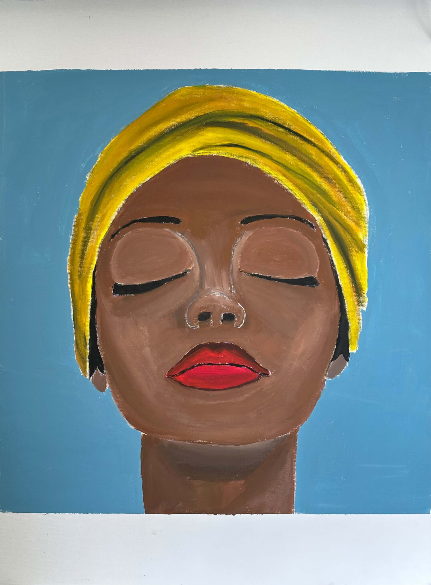 Eine Frau mit dunkler Hautfarbe trägt eine leuchtend gelbes Kopftuch.